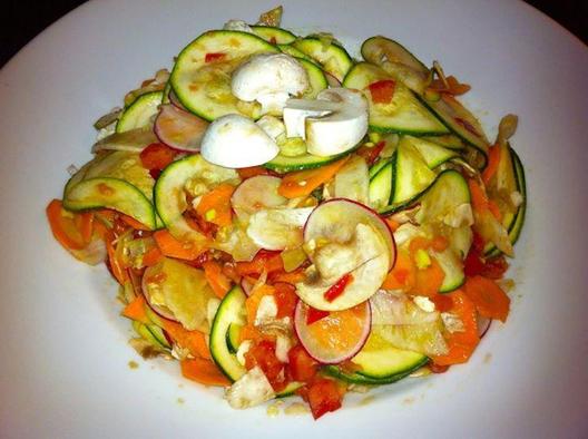 Ruw salade gemaakt van courgette, radijs, venkel, wortelen en champignons met tomaat en avocado stukken ingemasseerd ...
