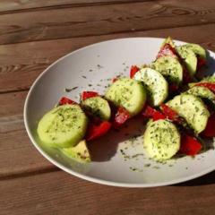 Komkommer, tomaat en avocado plakjes met een beetje citroensap en Italiaanse kruiden