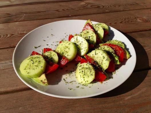 Komkommer, tomaat en avocado plakjes met een beetje citroensap en Italiaanse kruiden
