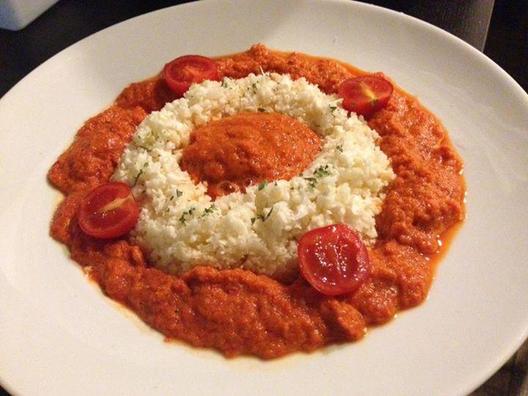 Bloemkool "rijst" met een rode puntpepers, wortel, avocado, peterselie saus met een vleugje citroensap en cocktailtomaten als garnering