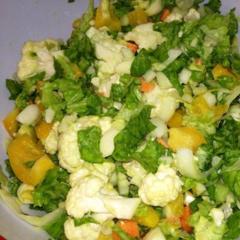 Salade met bloemkool, cicorie, groene sla, gele paprika, wortelen, avocado en citroensap.
